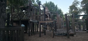 The wooden castle playground at Leonard Park on a late-August evening.