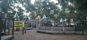 The castle towers of the Leonard Park playground under the oaks.