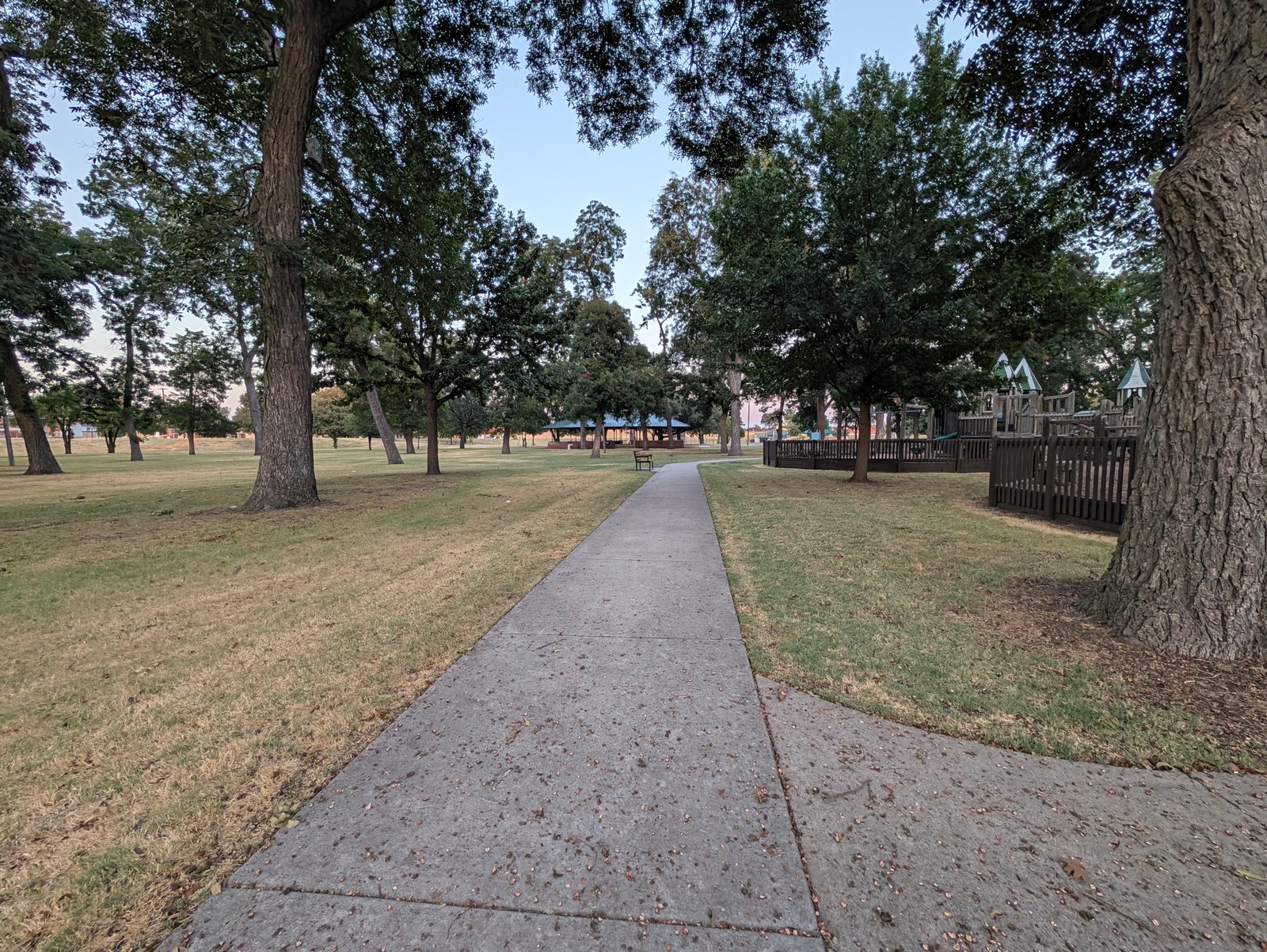 Paved walking path through the trees at Leonard Park.
