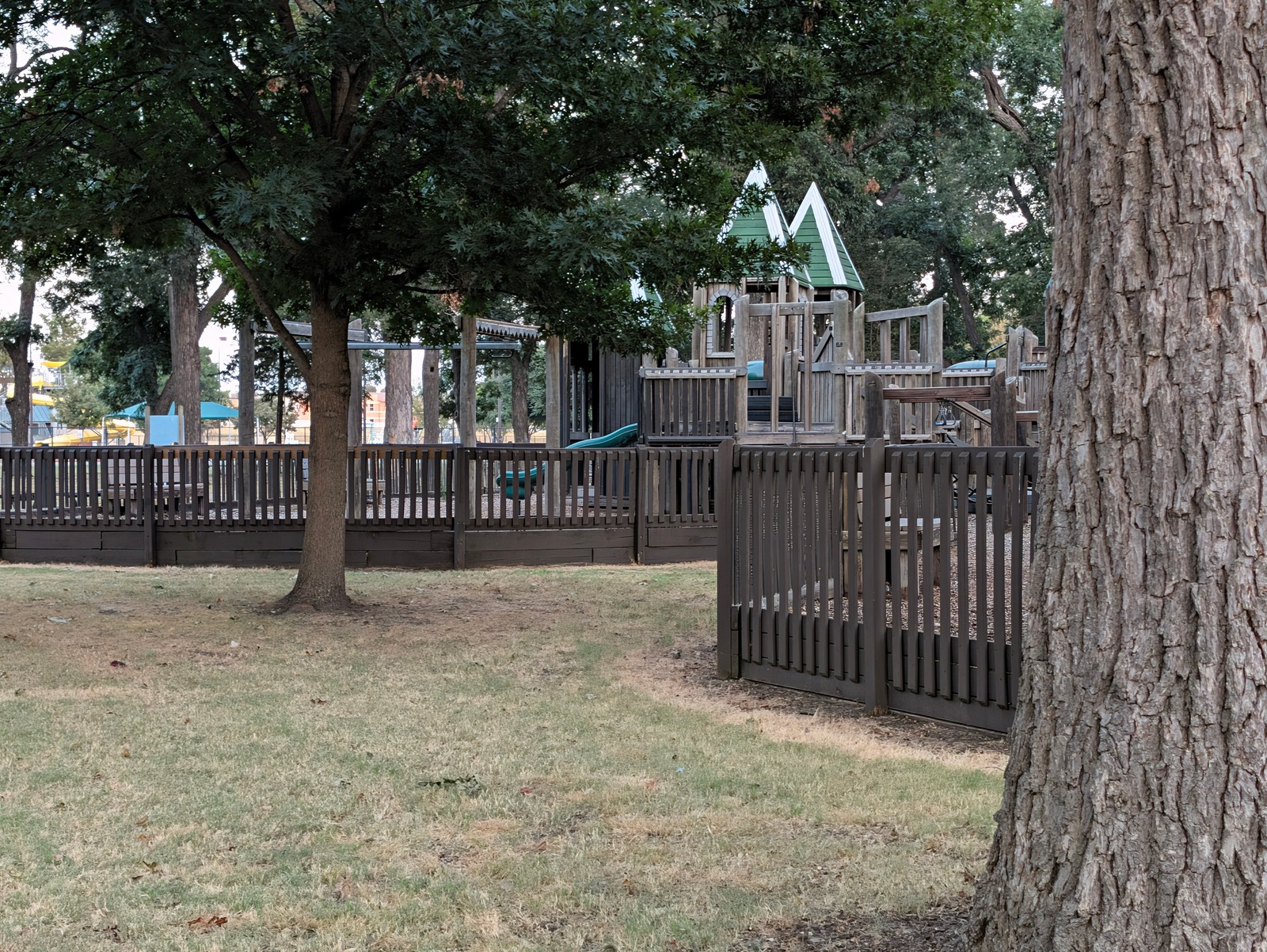 The playground behind its wooden fence at Leonard Park.