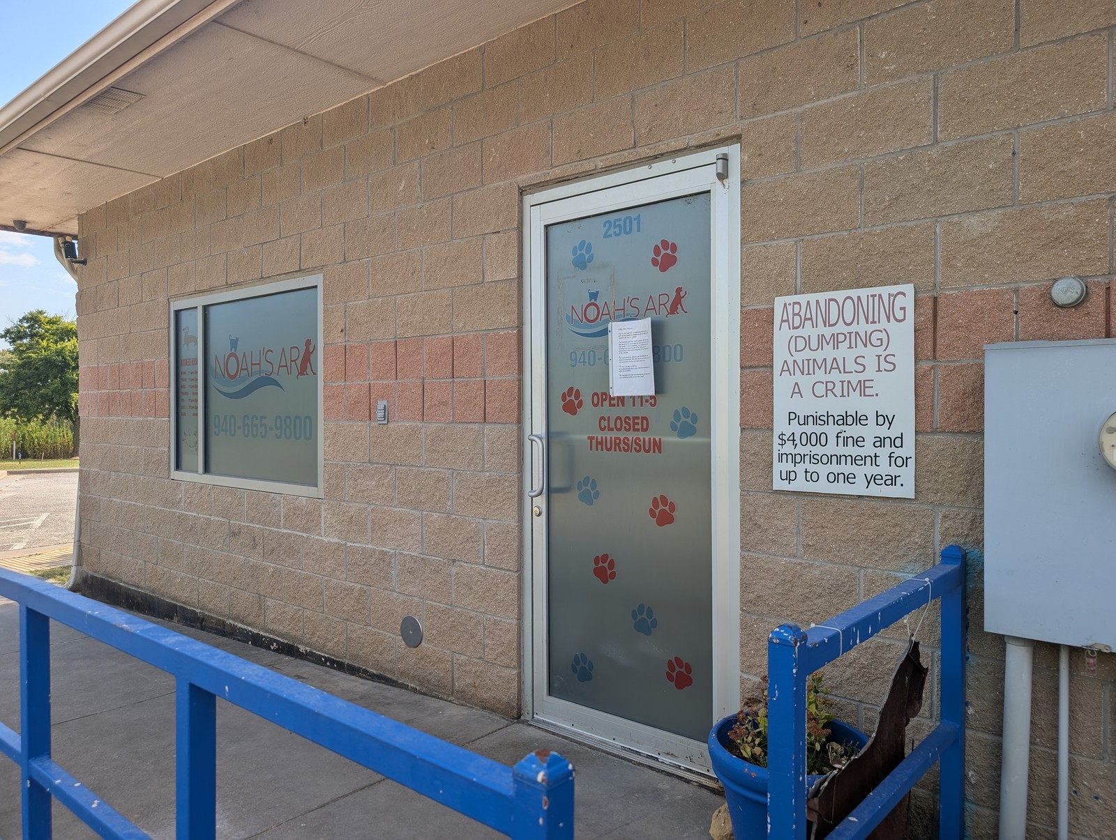 The entrance door at Noah's Ark SPCA with the shelter's hours posted.