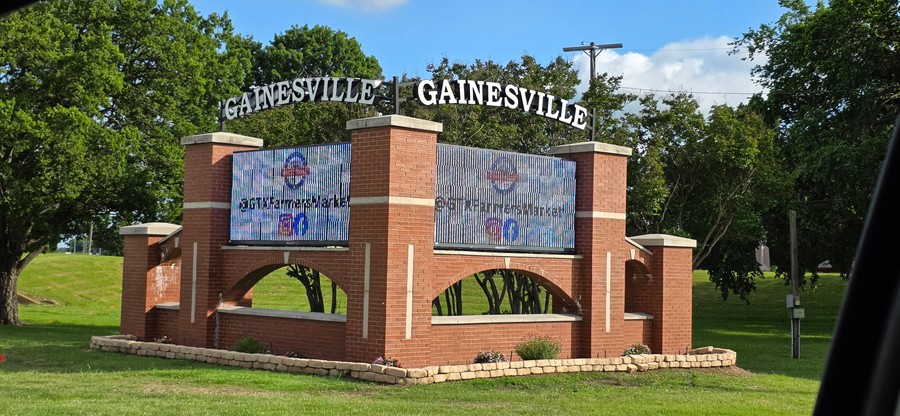 The brick Gainesville welcome monument on West California Street, May 2026.