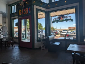 Looking out through the hand-painted window at St. Joe's Pizza on North Commerce Street, June 2024.