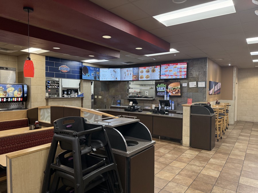 The order counter and dining room at the Dairy Queen on West California Street, with the menu boards lit above the registers.