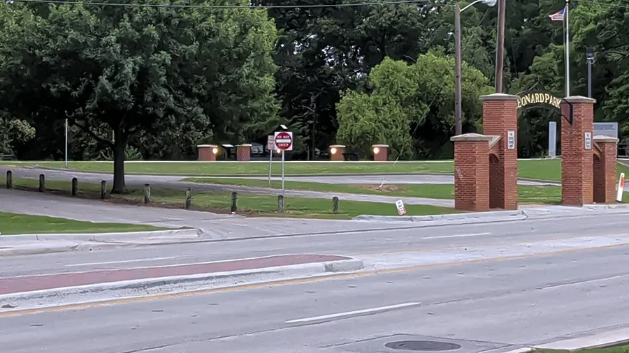 The brick gateposts of Leonard Park from across West California Street on a cloudy evening.