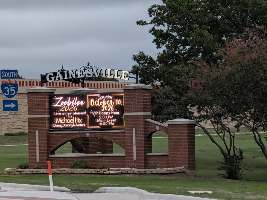 The brick "Gainesville" marquee at I-35 and California Street announcing Zoobilee 2026 on Saturday, Oct. 10, with an I-35 South sign beside it.
