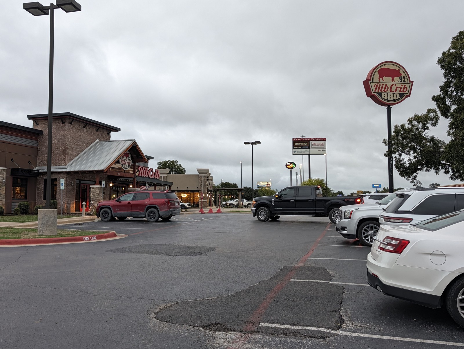 Rib Crib's stone-and-metal-roof building and tall pole sign across the parking lot.