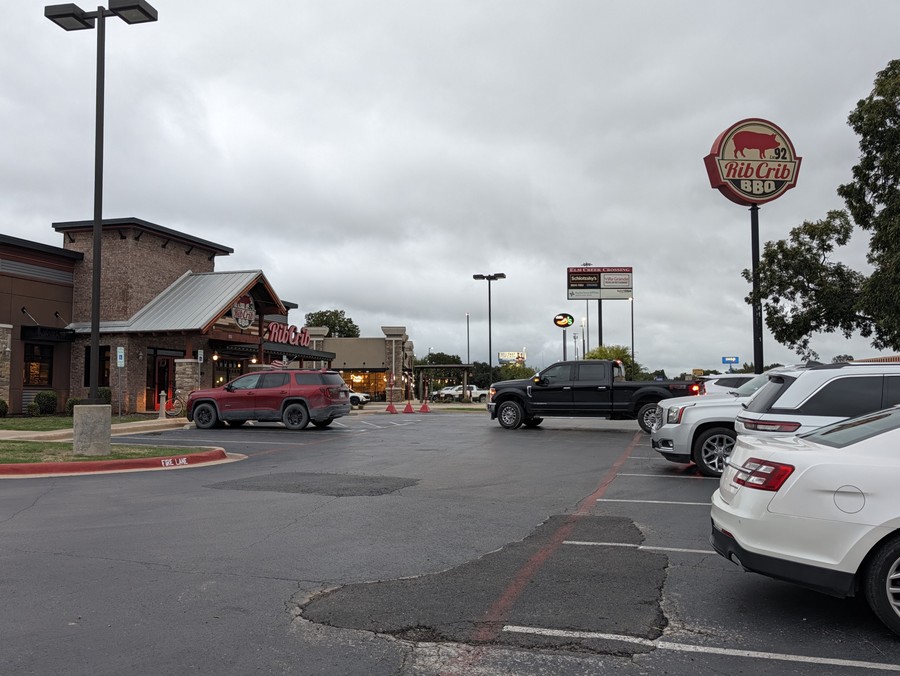 Rib Crib's stone-and-metal-roof building and tall pole sign across the parking lot.