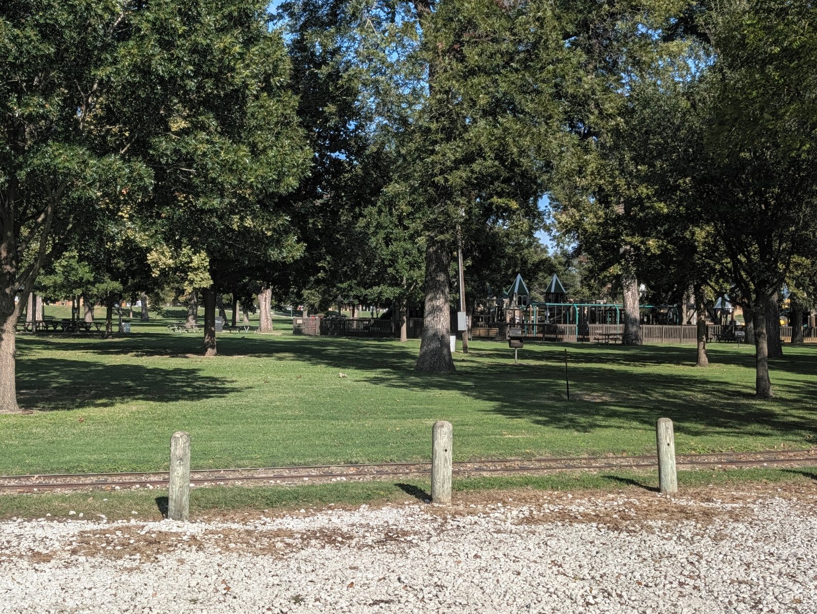 The playground and picnic tables sit under a canopy of trees at Leonard Park.