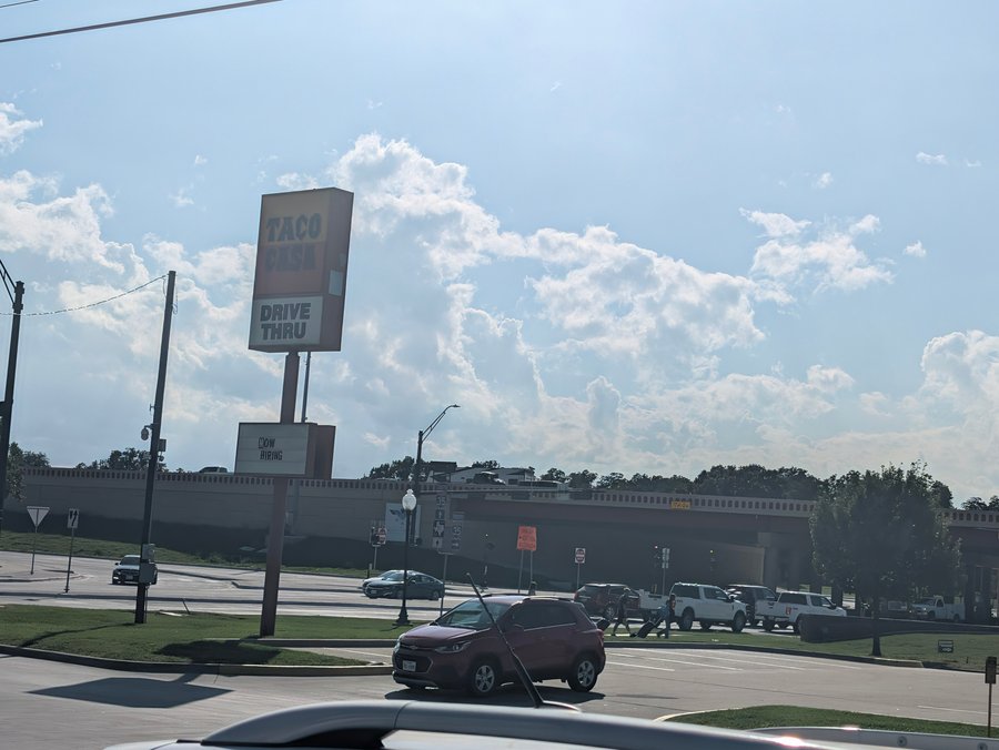 The Taco Casa drive-thru sign stands over West California Street, with the I-35 overpass behind it.