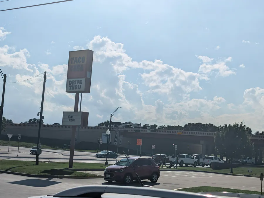 The Taco Casa drive-thru sign stands over West California Street, with the I-35 overpass behind it.