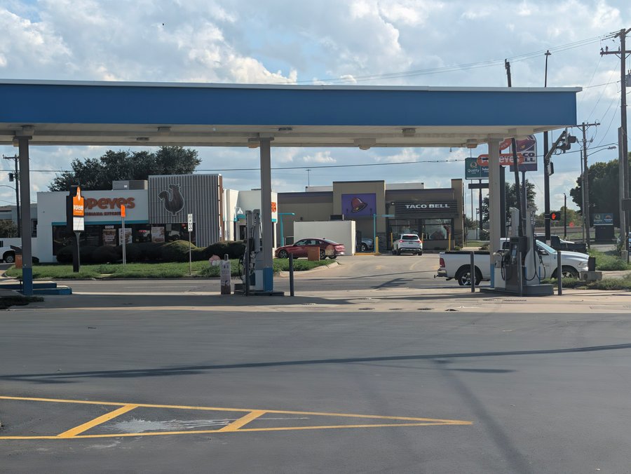 Popeyes and Taco Bell stand across the road from a fuel canopy near I-35.