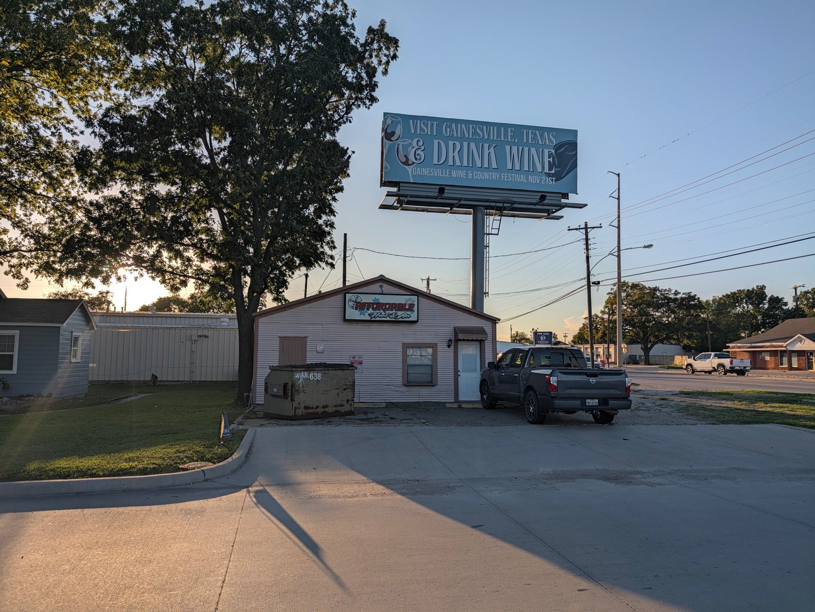 The Affordable Heat & Air shop sits under a billboard for the Gainesville Wine & Country Festival.