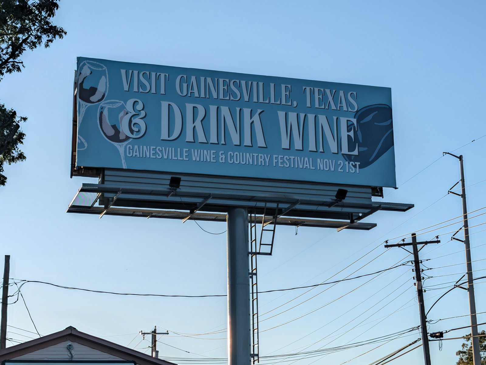 A billboard reads "Visit Gainesville, Texas & Drink Wine" and promotes the Gainesville Wine & Country Festival on Nov. 21.