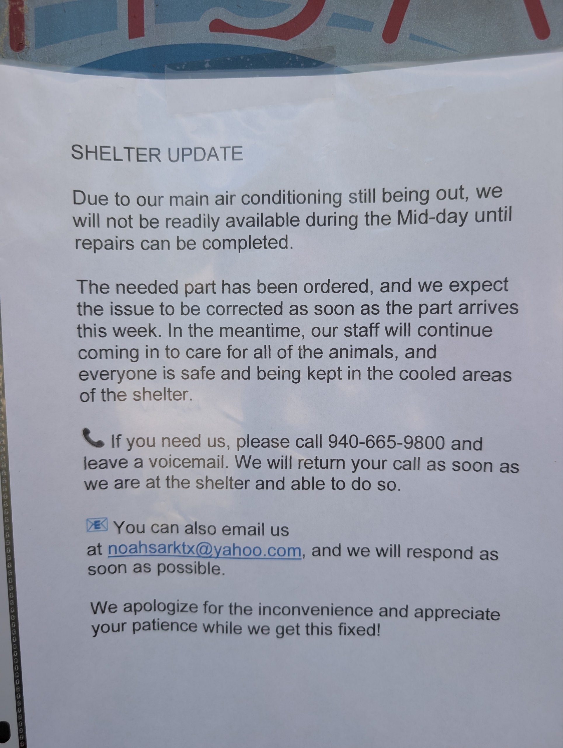 A printed SHELTER UPDATE notice in a plastic sleeve taped to the shelter's glass front door.